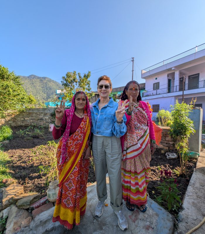 International tourist enjoying a meaningful travel experience with an Indian village community during her experiential travel in rural India.